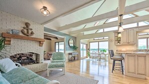 A spacious living area with a fireplace, a dining area, and a kitchen. - Large Lake House: Expansive View (Paw Paw)