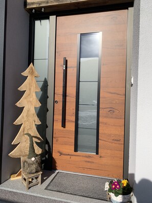 Eine Holztür mit einem satinierten Glasspiegel und einem schwarzen Griff.
