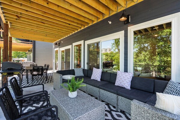 An outdoor patio with a covered seating area, a grill, and a dining table. - Private Hot Tub Retreat with Stunning Lake Views, Games & Near Branson Landing (Branson)