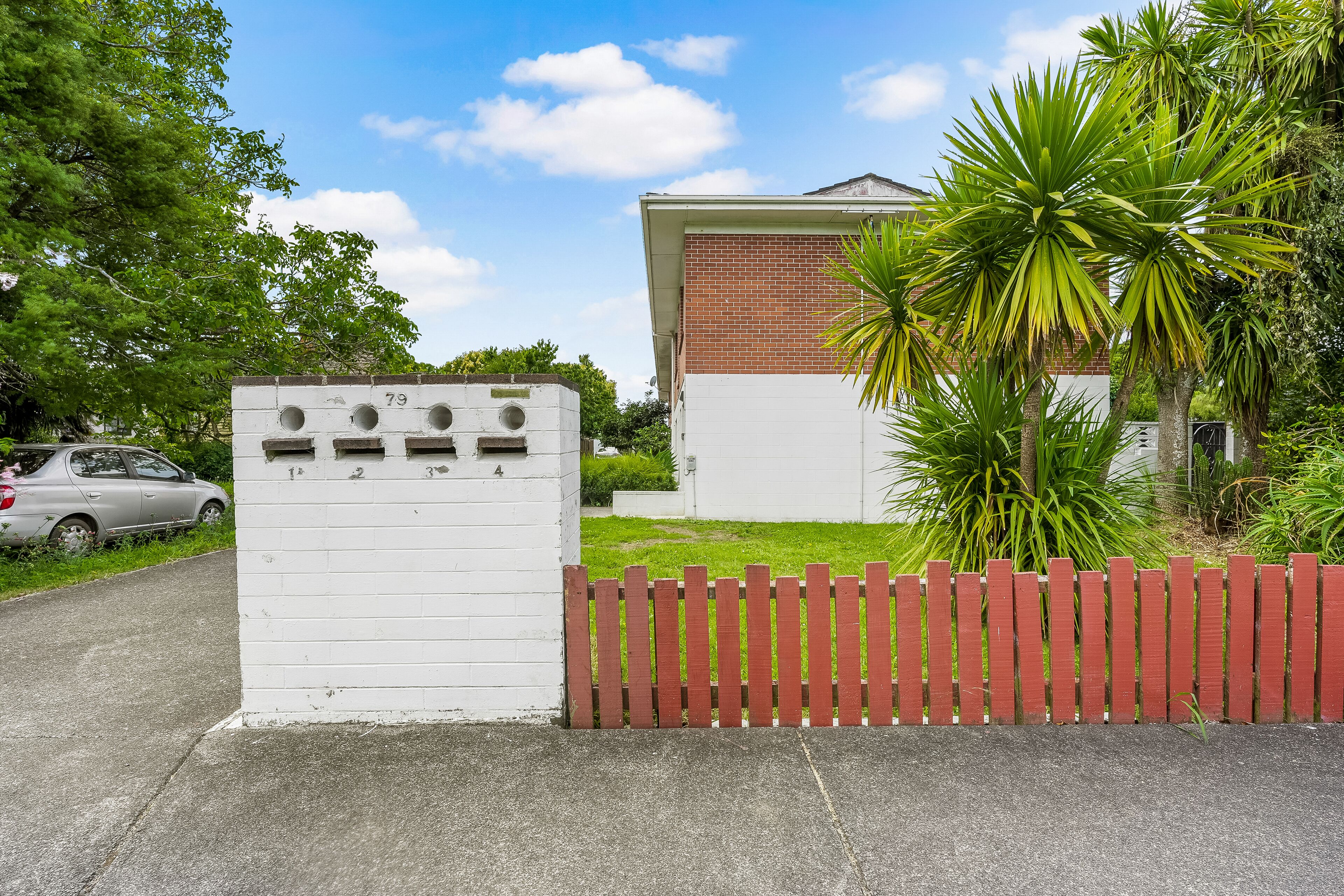 A gated property with a white building and a red fence.