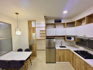 Enjoy cooking in this well-equipped kitchen with a gas stove, microwave, and stainless steel refrigerator.