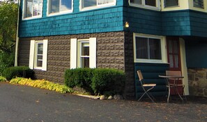 Une maison à deux étages avec une façade en pierre et un revêtement bleu.
