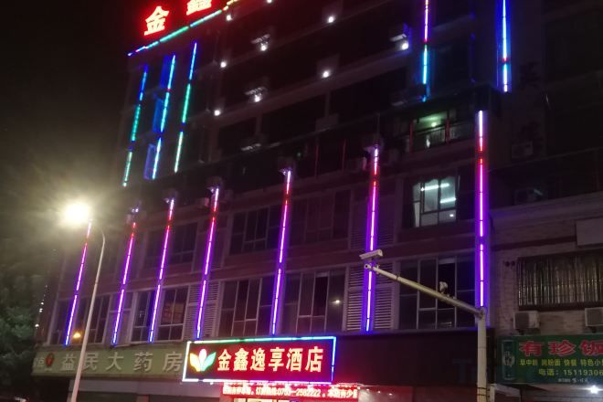 A multi-story building with illuminated signage and windows.