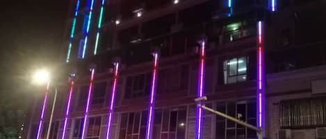 A multi-story building with illuminated signage and windows.