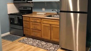 A compact kitchen with wooden cabinets, a stainless steel refrigerator, a microwave, and a stove. - Great View Guest Unit/Near Eden Hospital/Kaiser SL (San Leandro)