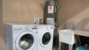 Een wasserette met twee voorladers, een boiler en een wasbak.