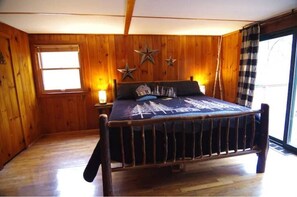 Ett rum med träpanel på väggarna, en säng, ett fönster och en stjärndekoration på väggen.