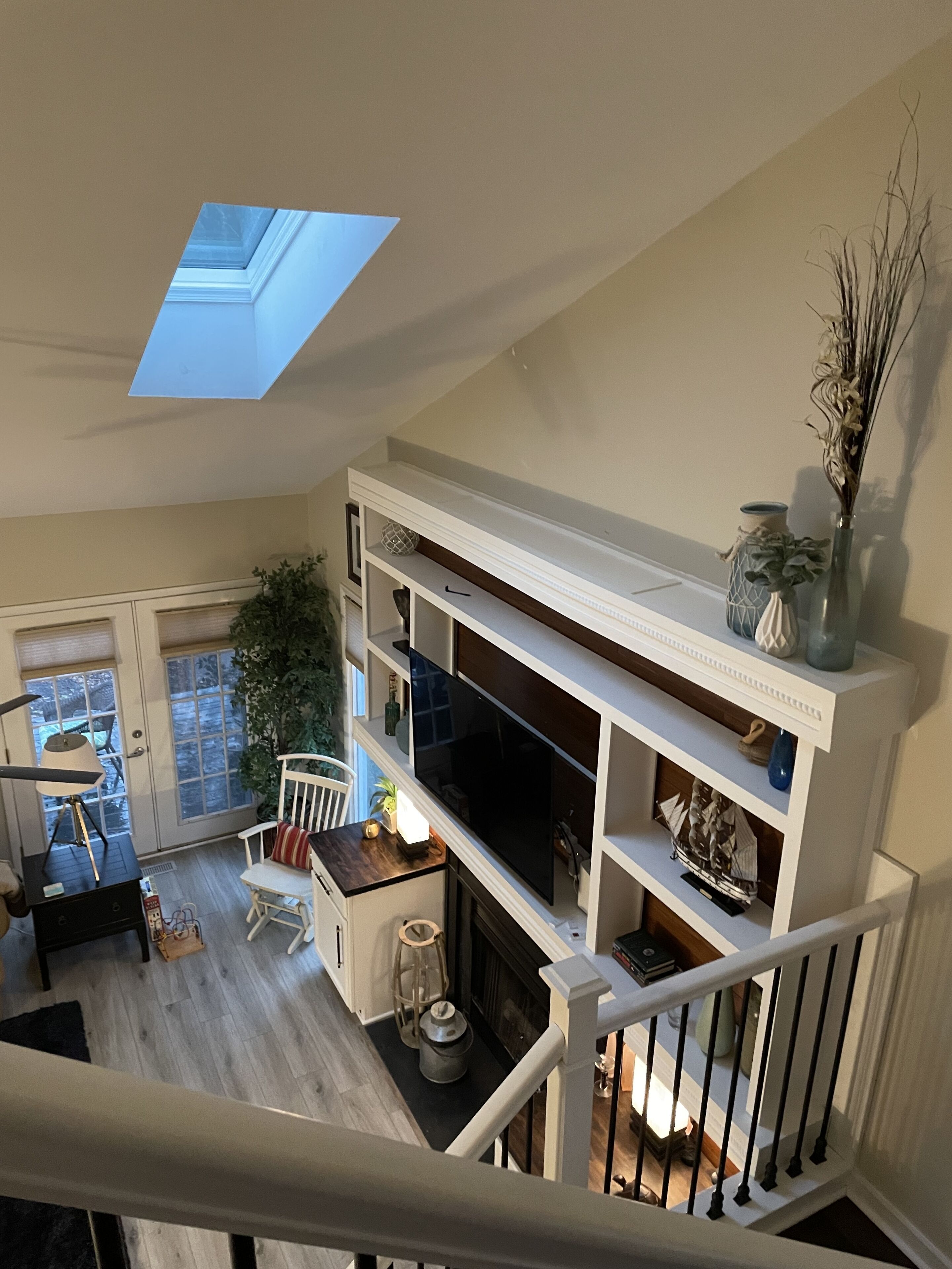 A multi-level living space with a skylight, a fireplace, and a staircase.