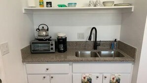 A kitchen with a toaster, kettle, coffee maker, and a sink. - Private Studio/Downtown/Free Washer/Dryer/Fast Wi-Fi (Castro Valley)