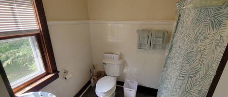 Une salle de bain avec des toilettes, un lavabo et une fenêtre.