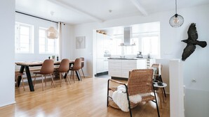 Una cocina moderna con armarios blancos, una isla central y una lámpara colgante.