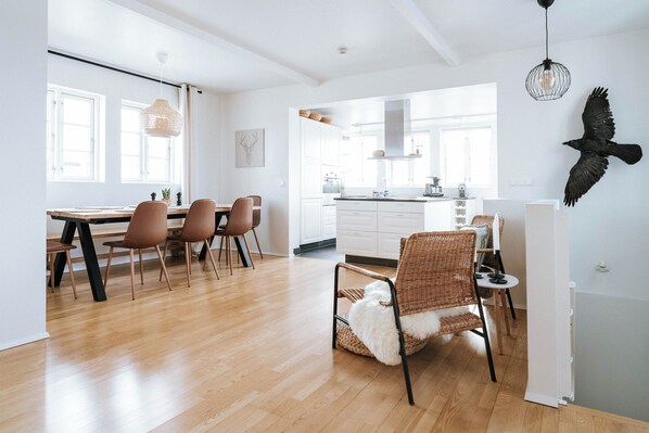 A modern kitchen with white cabinets, a central island, and a hanging light fixture.