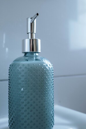 A clear view of a bathroom sink with a soap dispenser.