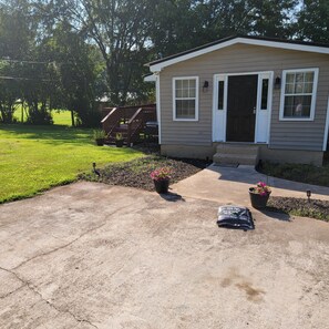 A single-story house with a front porch, a small deck, and a well-maintained lawn.