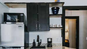 A compact kitchen with a refrigerator, microwave, sink, and coffee maker. - Lake Side Guest House with Hot Tub (White Cloud)