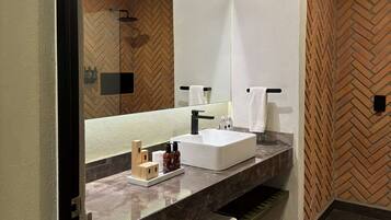 Un baño moderno con un espejo grande, un lavamanos blanco y un revestimiento de pared con motivo de espinilla.