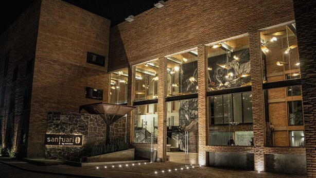 A modern building with a stone facade, large windows, and a sign reading "santuari". - Esplendor by Wyndham San Luis Potosi (San Luis Potosi)
