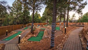 A miniature golf course with multiple holes, surrounded by trees and a wooden fence. - 2BD/Flagstaff - Full Kitchen, Living Room, W/D and Balcony! (Flagstaff)