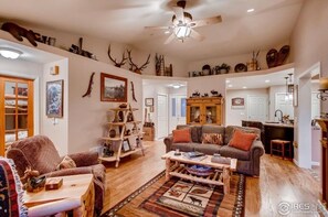 Una sala de estar acogedora con chimenea, muebles de madera y adornos de asta.