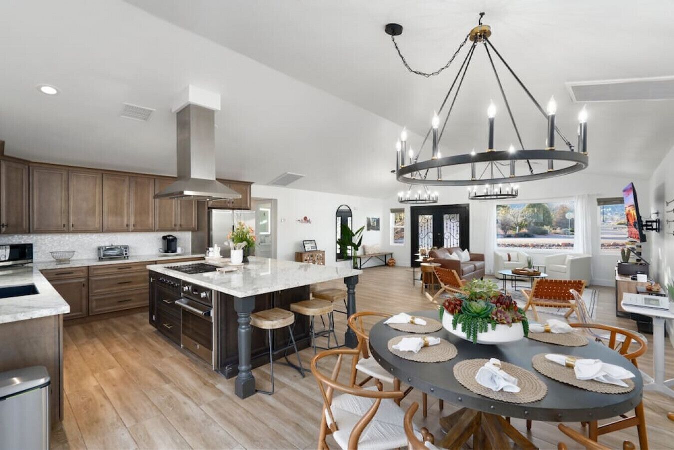 A spacious kitchen with a large island, wooden cabinets, and modern appliances.