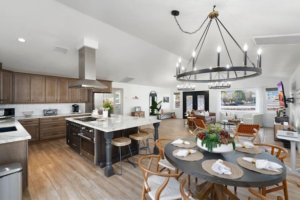 A spacious kitchen with a large island, wooden cabinets, and modern appliances.