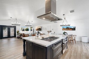 A spacious kitchen with a large island, dark cabinetry, and pendant lighting. - Lovely 5-STAR gem by trails, views, hot tub, games. Hikes and restaurants close. (Sedona)