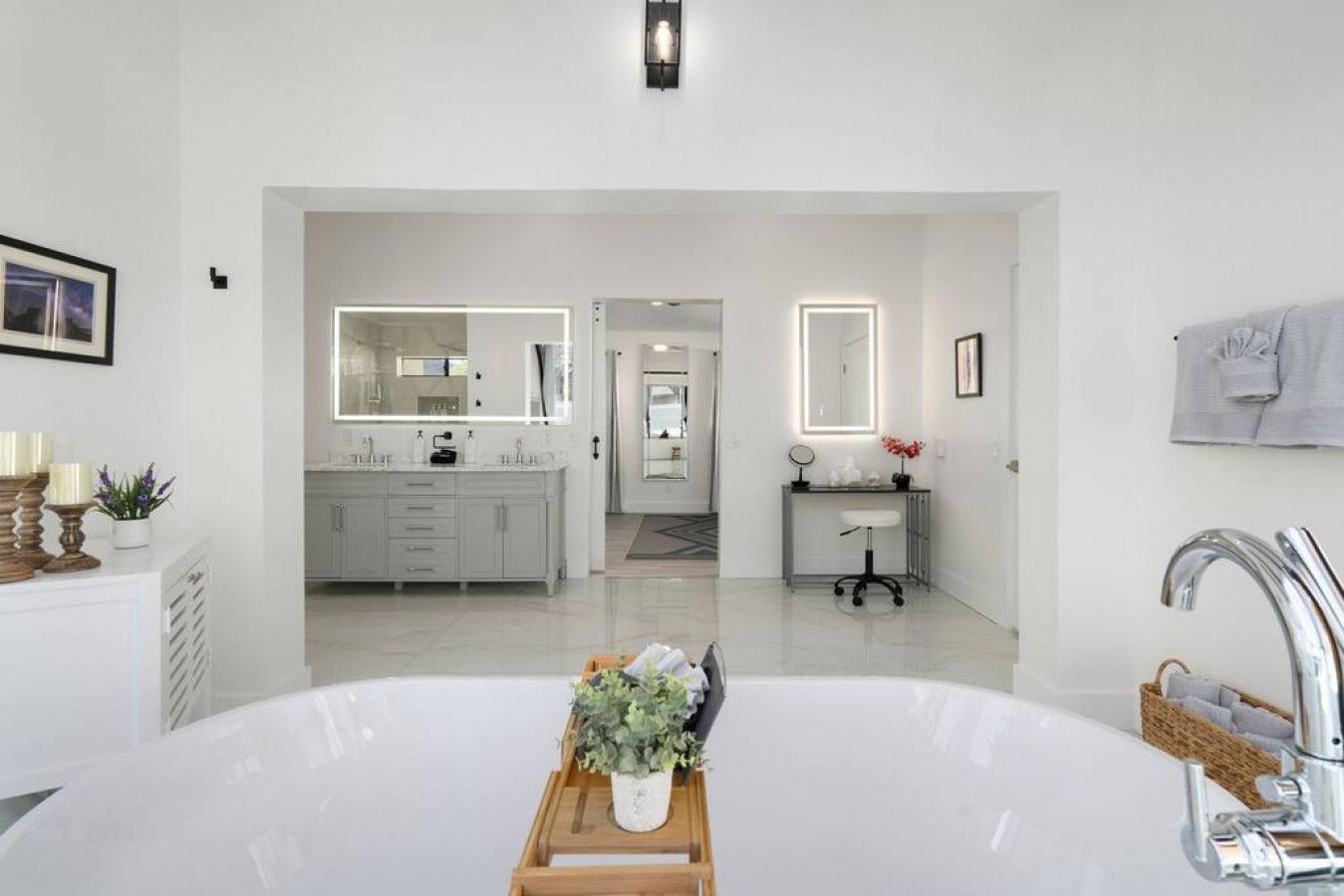 Une salle de bain moderne avec une grande baignoire, un meuble-lavabo avec un miroir et un espace lavabo séparé.