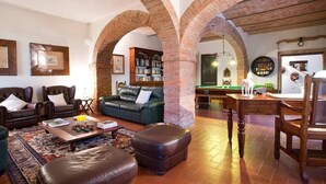 A cozy living room with leather sofas, a coffee table, and a bookshelf. - Villa Montelisi, With The most Unique View On Siena (6km) (Siena)