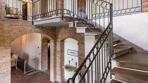 A multi-level stone staircase with wrought iron railings, leading to an upper floor.