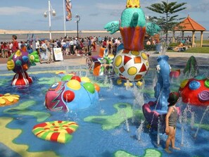 A water park with various colorful water features and a crowd of people. - GoneToTheBeach - Beach, Spa, Pool table, Pets, Boards, Rods, Bikes. 
 Awesome. (The Entrance North)