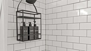 A bathroom with white tiled walls and a corner shower area. - 175 LEX - Walkable Downtown Lexington - Top Floor (Lexington)