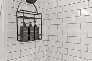 A bathroom with white tiled walls and a corner shower area. - 175 LEX - Walkable Downtown Lexington - Top Floor (Lexington)