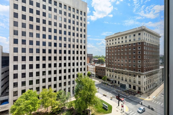 A view of a cityscape with a modern high-rise building and a historic brick building.