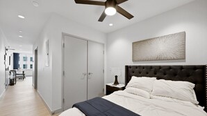 A bedroom with a bed, a nightstand, a ceiling fan, and a wardrobe. - 175 LEX - Walkable Loft to Rupp Arena & Downtown! (Lexington)