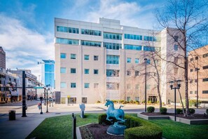 A modern building with a glass facade, surrounded by a well-maintained garden with a statue of a horse. - 175 LEX - Walkable Loft to Rupp Arena & Downtown! (Lexington)