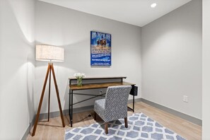 A room with a desk, a lamp, a chair, and a poster on the wall. - 175 LEX - Walkable Downtown Lexington Condo (Lexington)