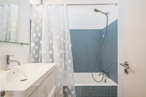 Banheira, secador de cabelo, toalhas de banho 