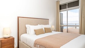 A hotel room with a large bed, two bedside tables, and a window with curtains. - Casa Branca 360 - Penthouse - By Wehost (Funchal)
