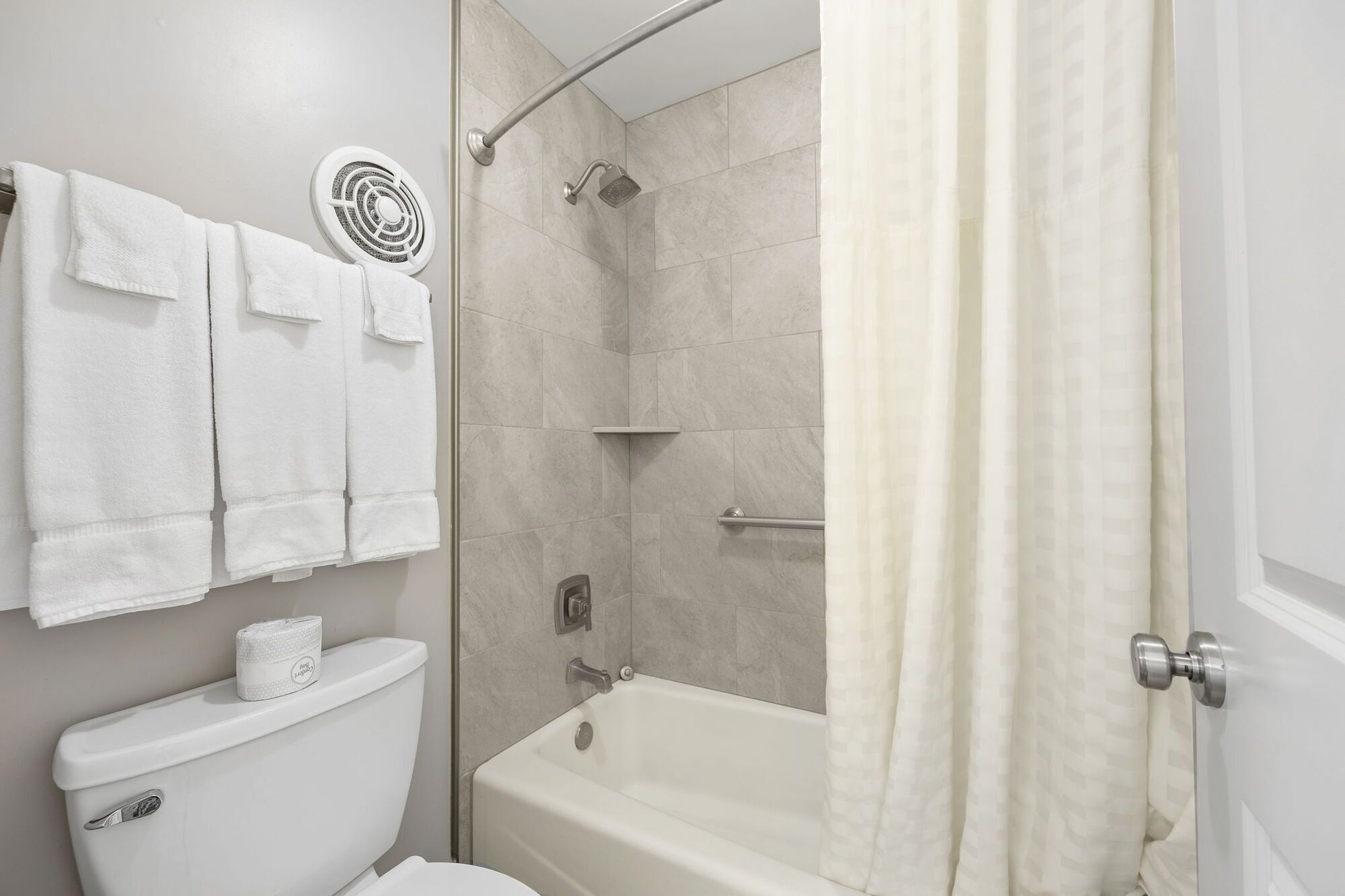 A bathroom with a toilet, a shower with a glass door, and a bathtub.