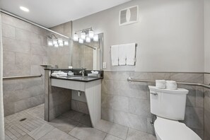 Et moderne badeværelse med bruser, toilet og vask.