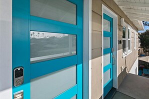 A turquoise door with a frosted glass panel and a keypad lock. - Modern, Newly Renovated 2BR Apt in Heart of OB (San Diego)