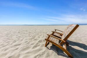Na praia, espreguiçadeiras, toalhas de praia 