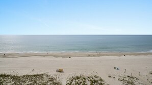 A wide sandy beach with a few people and a lifeguard tower. - Caravelle 505 Ocean view Efficiency w/pools (Myrtle Beach)