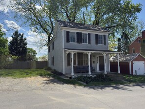 A two-story house with a porch, a garage, and a fenced yard. - Renovated 3B/3B Home | Downtown | Private Fire Pit (Leesburg)