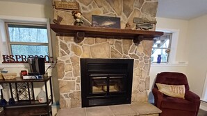 A stone fireplace with a coffee maker and a sign above it.