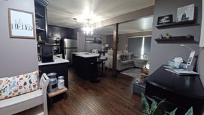 Een moderne woonruimte met een keuken, een eethoek en een gezellige zithoek.