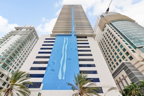 A tall, modern building with a distinctive blue vertical feature and multiple balconies. - The Club at Brickell Bay Luxury Suites (Miami)
