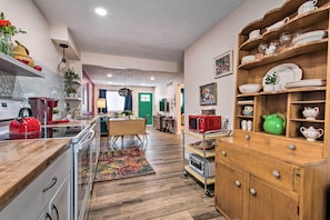 A kitchen with wooden cabinets, a microwave, and a red kettle.