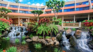 A hotel with a landscaped garden featuring a pond, waterfalls, and tropical plants. - Maui Resort Rentals: Marriott's Maui Ocean Club Studio Oceanfront Suite (Lahaina)