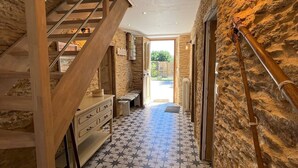 A staircase leading to a room with a stone wall, a tiled floor, and a bench.